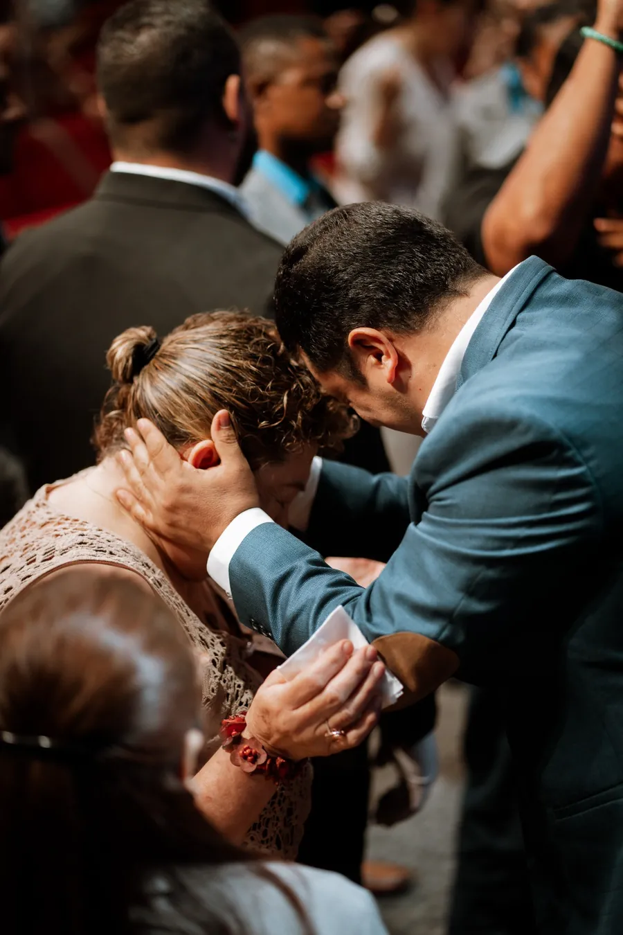 Pastor imponiendo manos y orando por una hermana de la congregación